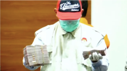 Petugas KPK menunjukkan barang bukti uang dalam Operasi Tangkap Tangan (OTT) di Pengadilan Negeri Surabaya dalam konferensi pers di Jakarta pada 20 Januari 2022. (Foto: Tangkapan layar)