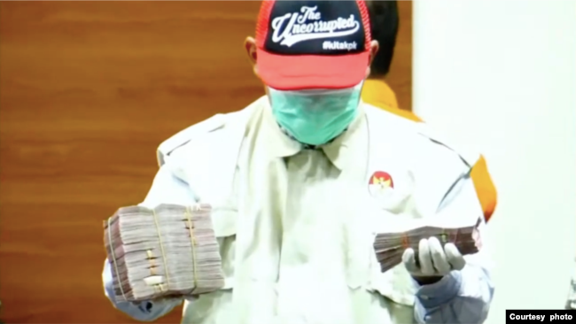 Petugas KPK menunjukkan barang bukti uang dalam Operasi Tangkap Tangan (OTT) di Pengadilan Negeri Surabaya dalam konferensi pers di Jakarta pada 20 Januari 2022. (Foto: Tangkapan layar)