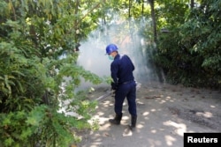 A worker fumigates an area in Yangon, Myanmar, in an attempt to destroy mosquitoes that might carry the Zika virus, Nov. 18, 2016.
