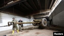 Rebel fighter clean a weapon in al-Rai town, northern Aleppo countryside, Syria, Dec. 25, 2016.