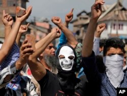 Masked Kashmiri protesters hold bricks as they shout freedom slogans in Srinagar, India, May 27, 2017.