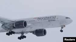 A 777-200ER plane owned by Russia's Nordwind Airlines descends before landing and completing a direct flight from the Venezuelan capital of Caracas at Vnukovo International Airport outside Moscow, Russia, Jan.31, 2019.