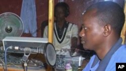 In this photo taken in 2010, the director of Shabelle radio station Hassan Osman Abdi, right, presents a program in the radio station's studio in Mogadishu, Somalia. Unidentified gunmen shot and killed Abdi, a 29-year-old father of three, on his way home 