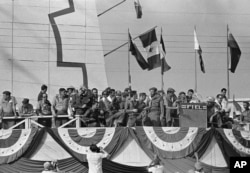 Cuba’s Prime Minister Fidel Castro, center, talks with soldier bodyguards while watching May Day parade in Havana May 1, 1961.