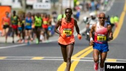 Boston Marathon elite runners Josphat Boit (left) and Meb Keflezighi (right) race to the finish line during the 2014 Boston Marathon in Massachusets, USA.