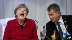 Almanya Başbakanı Angela Merkel Lahey'de Finlandiya Sauili Niinisto ile görüşmesinde kahkaha atarken 