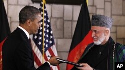 President Barack Obama and Afghan President Hamid Karzai sign a strategic partnership agreement at the presidential palace in Kabul, Afghanistan, May 2, 2012.