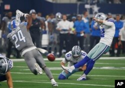 FILE - Dallas Cowboys kicker Brett Maher (2) kicks a field goal as punter Chris Jones (6) holds and Detroit Lions defensive back Nevin Lawson (24) defends in the first half of an NFL football game in Arlington, Texas, Sept. 30, 2018.