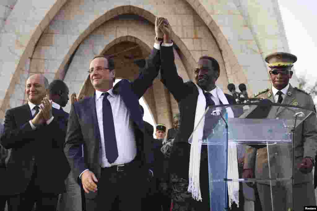 France's President Francois Hollande (2nd L) joins hands with Mali's interim president Dioncounda Traore at Independence Plaza in Bamako, Mali February 2, 2013.