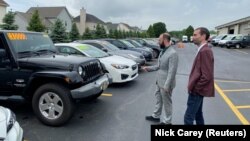 Alex Tovstanovsky, owner of Prestige Motor Works, checks on inventory with Ryan Caton after sales jumped in May following two down months because of the coronavirus disease (COVID-19) pandemic in Naperville, Illinois, U.S. May 28, 2020. (REUTERS/Nick Carey)