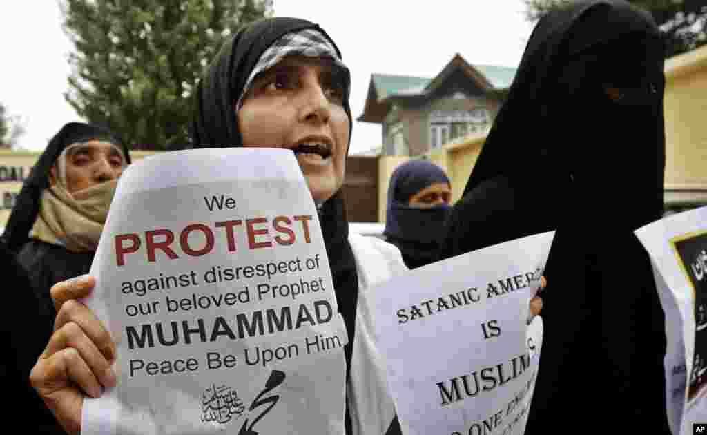 Yasmeen Raja, chairperson of Muslim Khawateen Markaz, or Muslim Women's Center, holds placards as she shouts slogans during a protest against the "Innocence of Muslims" film in Srinagar, India, Sept. 17, 2012.