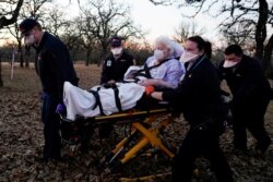 Paramedis bersiap untuk mengangkut seorang wanita berusia 87 tahun yang telah terpapar Covid-19 dan mengalami gejala di Meeker, Oklahoma, AS 20 Desember 2020. (Foto: REUTERS/Nick Oxford)