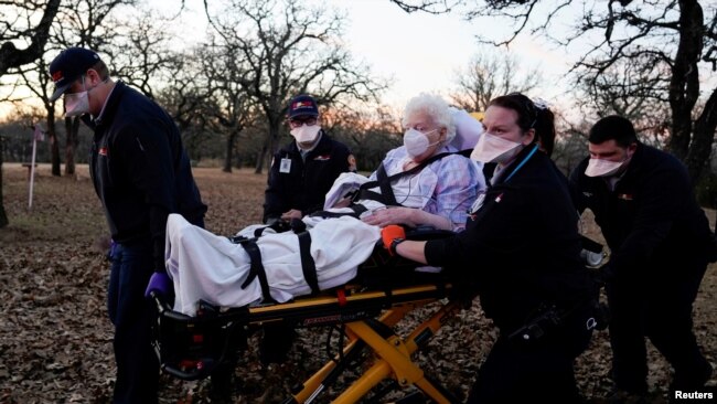 Des ambulanciers transportent une femme de 87 ans qui avait été exposée à la maladie COVID-19 à Meeker, Oklahoma, aux États-Unis, le 20 décembre 2020.