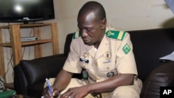 Mali's military junta leader, Captain Amadou Sanogo signs documents as the junta and the West African bloc ECOWAS announced a deal that includes the lifting of sanctions and an amnesty for those involved in last month's coup at the Kati military camp, nea