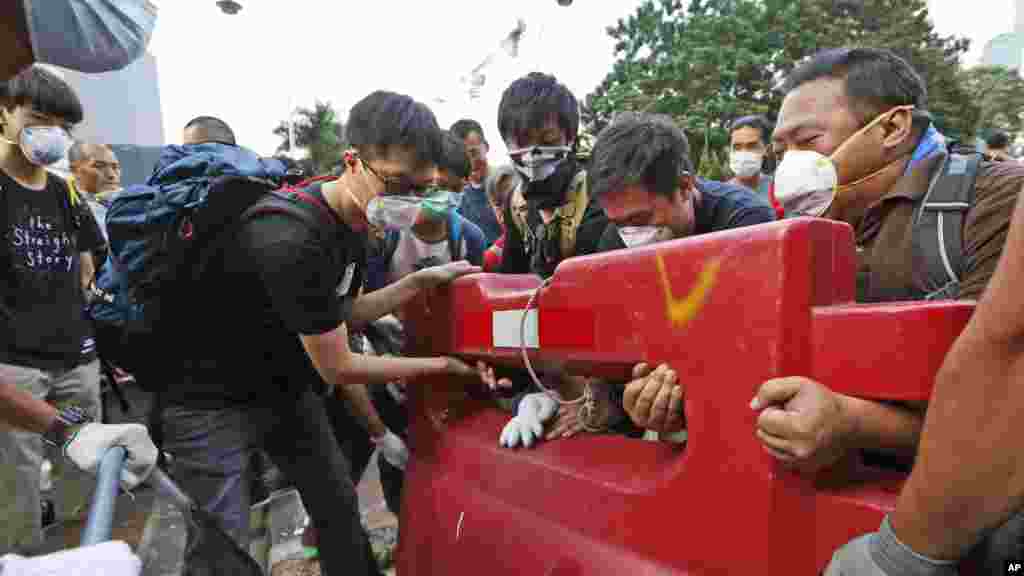 Des manifestants pro-démocratie érigent une barricade sur la route principale dans les zones occupées en dehors du siège du gouvernement à l&#39;Amirauté de Hong Kong, le lundi 13 octobre 2014. (AP Photo / Kin Cheung) 