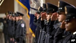 FILE - The newest members of the U.S. Capitol Police salute during their graduation ceremony on Capitol Hill in Washington, Nov. 20, 2015.