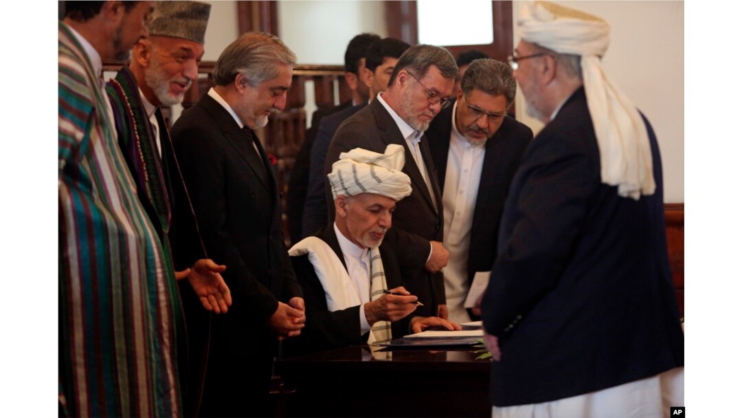 Afghan President Ashraf Ghani, center, signs a peace agreement with Gulbuddin Hekmatyar, a notorious warlord on terrorist blacklists, at the presidential palace in Kabul, Sept. 29, 2016.