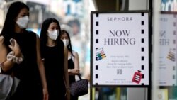 FILE - A sign advertising job openings is seen as people walk into a store in New York City, Aug. 6, 2021.