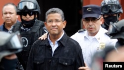 Former El Salvador President Francisco Flores (C) walks out of his house while being guarded by Deputy Director of Police Howard Cotto (R) and the elite unit Reaction Police Group (GRP) in San Benito neigborhood, San Salvador, Sept. 19, 2014.