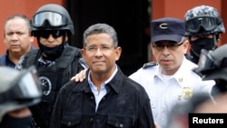 Former El Salvador President Francisco Flores (C) walks out of his house while being guarded by Deputy Director of Police Howard Cotto (R) and the elite unit Reaction Police Group (GRP) in San Benito neigborhood, San Salvador, Sept. 19, 2014.
