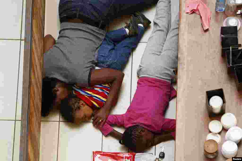 2013年9月21日，在内罗毕遭到袭击的韦斯特盖特购物中心，一名母亲和她的孩子躲避枪手的追击。