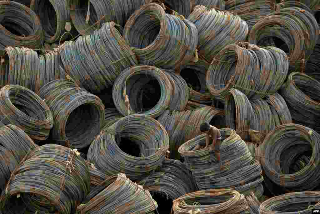 A child looks for metal scraps among cables on a barge in Manila, Philippines.