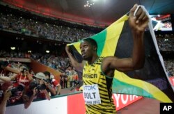 Jamaica's Usain Bolt celebrates after winning the gold medal in the men's 100m ahead of United States' at the World Athletics Championships at the Bird's Nest stadium in Beijing, Sunday, Aug. 23, 2015.