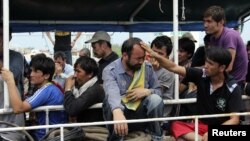 Asylum seekers from Afghanistan, Iraq and Iran cry as Indonesian officers force them to leave the Australian vessel Hermia docked at Indah Kiat port in Merak, Indonesia's Banten province, April 9, 2012. 