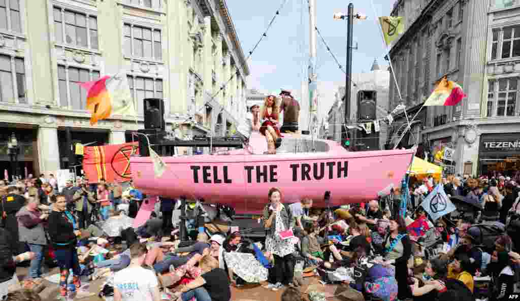 Climate change activists listen to speeches at their encampment blocking the road junction at Oxford Circus in the busy shopping district in central London during the fourth day of an environmental protest by the Extinction Rebellion group.