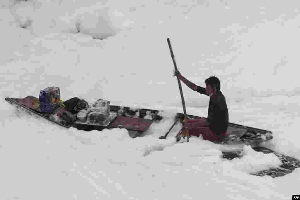 A man rows his boat in the polluted Yamuna river on the outskirts of New Delhi, India.