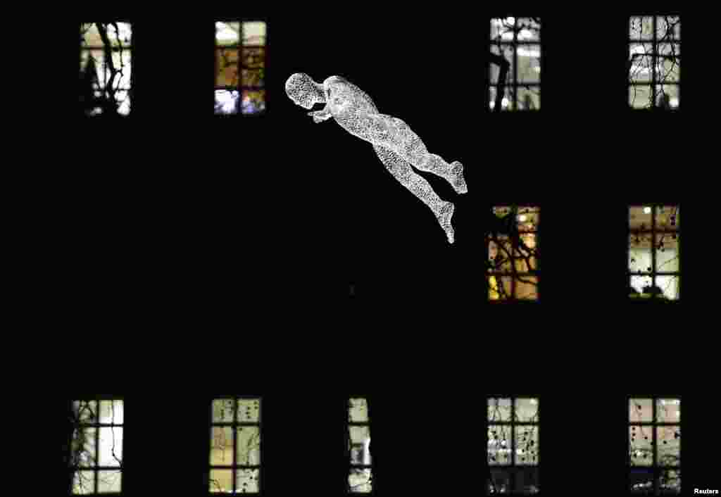 Phần được chiếu sáng của tác phẩm &quot;The Travellers&quot; của Cedric Le Borgne được nhìn thấy treo lơ lửng bên trên Quảng trường St. James như trong lễ hội Ánh sáng ở London, ngày 14 tháng 1, 2016. Sự kiện này diễn ra trong bốn buổi tối, với những kiến trúc biểu tượng nổi tiếng và những tác phẩm nghệ thuật của những nghệ sĩ quốc tế được thắp sáng.