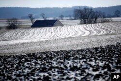 The sun reflects off of snow and ice on a farmer's frozen field in Ronks, Pennsylvania, Jan. 2, 2018.