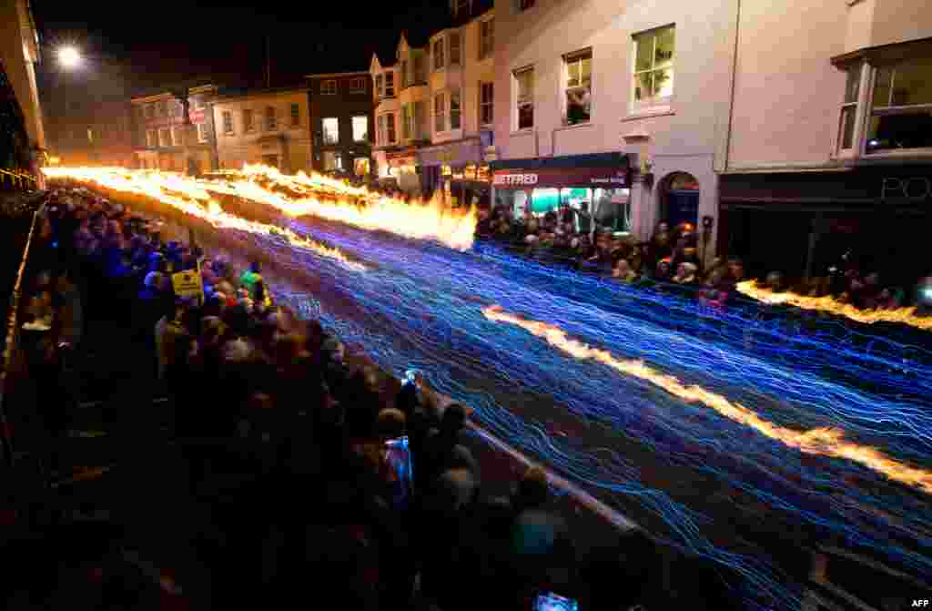 Warga setempat berkumpul untuk menyaksikan parade tradisional 'Bonfire' melalui jalan-jalan di Lewes, Sussex, Inggris.