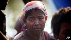 FILE - A rescued migrant weeps upon arrival in Simpang Tiga, Aceh province, Indonesia, Wednesday, May 20, 2015. Authorities in Aceh are preparing to tow a boat with more than 40 Tamil men, women and children out to sea Friday after rescuing it last weekend.