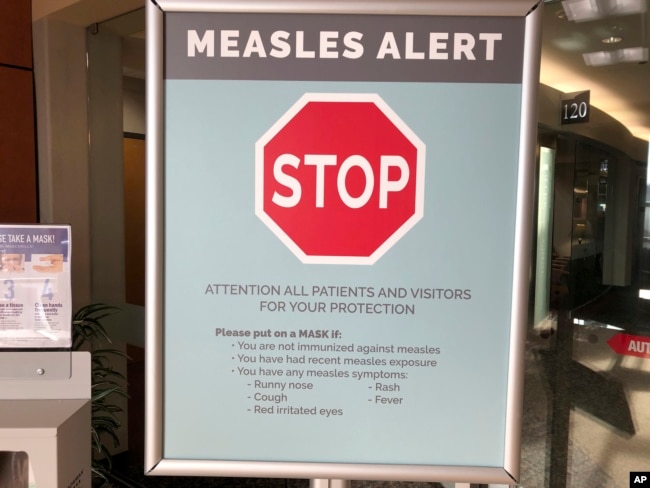 Signs posted at a clinic in Vancouver, Washington warns patients and visitors of a measles outbreak. A measles outbreak near Portland, Ore., has revived a bitter debate over personal belief exemptions to childhood vaccinations, 2019. (File Photo)