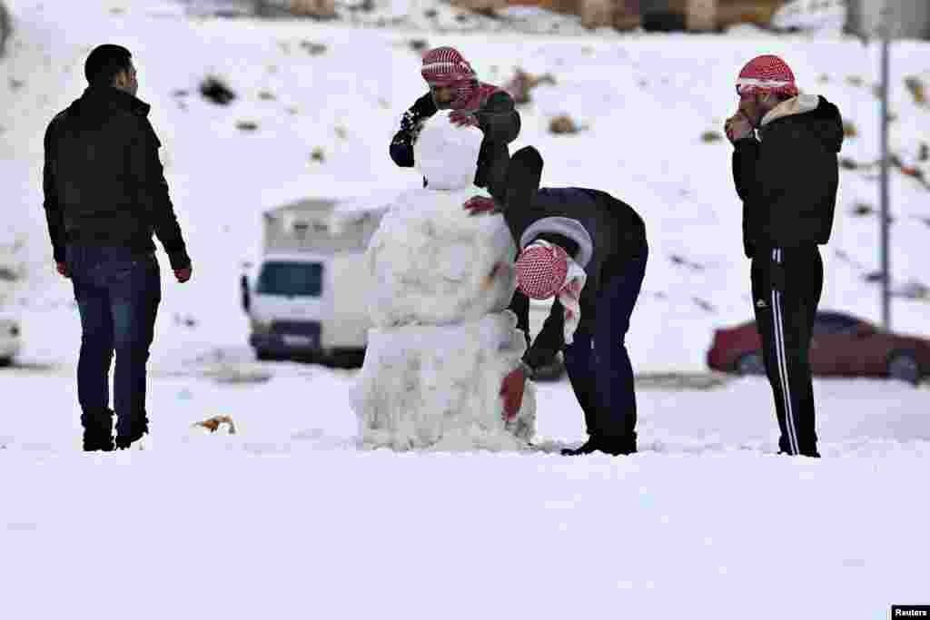 People play with snow after a heavy snowstorm in Amman, Jordan.