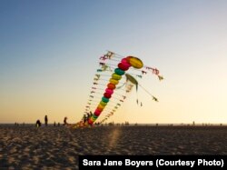 Tyrus Wong's centipede kite begins to rise into the sky above Santa Monica Beach.