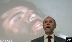 FILE - Frank Lindh is shown speaking to law students in front of a projected image of his son, John Walker Lindh, at the University of San Francisco in San Francisco, Feb. 16, 2011.