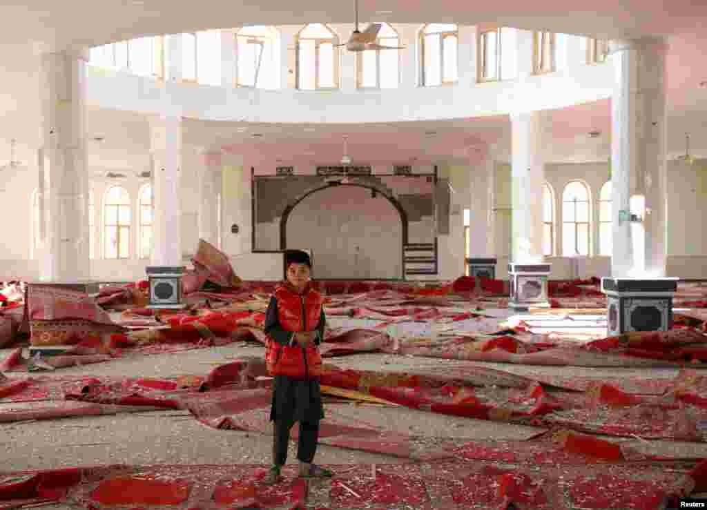 A boy stands inside a damaged mosque at the site of an attack in a U.S. military air base in Bagram, north of Kabul, Afghanistan.