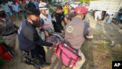 Rescatistas trasladan a una mujer herida en el accidente de un camión con migrantes en una autopista en Tuxtla Gutiérrez, en el estado de Chiapas, México, el 9 de diciembre de 2021. 