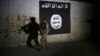 FILE - An Iraqi soldier inspects a former train tunnel displaying the the Islamic State group flag, in western Mosul, Iraq, March 1, 2017. 