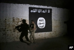 FILE - An Iraqi soldier inspects a former train tunnel displaying the the Islamic State group flag, in western Mosul, Iraq, March 1, 2017. The tunnel once served as a training camp for IS fighters.