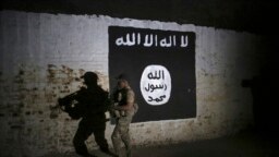 FILE - An Iraqi soldier inspects a former train tunnel displaying the the Islamic State group flag, in western Mosul, Iraq, March 1, 2017. The tunnel once served as a training camp for IS fighters.