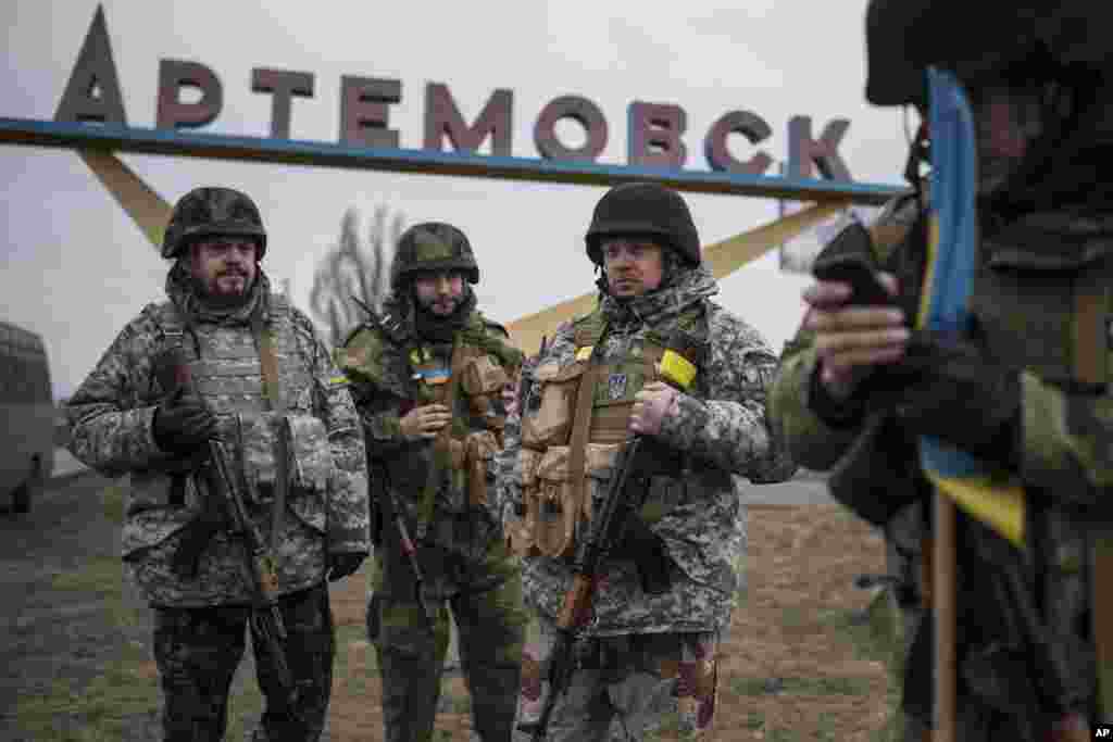 Ukrainian servicemen stand near an area where fighting has waned substantially in recent days as a cease-fire deal forged last month increasingly takes effect, eastern Ukraine, March 3, 2015.