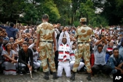 FILE - Ethiopian soldiers try to stop protesters in Bishoftu, in the Oromia region of Ethiopia.