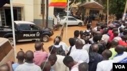 Protesters line up in front of Kira Road Police Station where opposition candidate Kizza Besigye was detained while campaigning for president, Kampala, Feb. 15, 2016. (E. Paula/VOA)