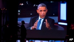 A Secret Service Agent stands by a screen showing a live feed as President Barack Obama talks with Jimmy Kimmel while they are taped on Jimmy Kimmel Live, in Los Angeles, Thursday, March 12, 2015.