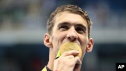 Michael Phelps merayakan peraihan medali emas di estafet gaya bebas 4x200-meter pria di Olimpiade Rio, Brazil Rabu (10/8).