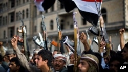 Shiite rebels, known as Houthis, hold up their weapons as they attend a protest against Saudi-led airstrikes in Sanaa, Yemen, April 10, 2015. 