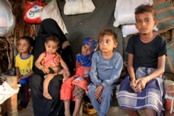 Bocah malnutrisi Hassan Merzam Muhammad duduk bersama ibu dan saudara laki-laki dan perempuannya di dalam gubuk mereka di distrik Abs provinsi Hajjah, Yaman, 20 November 2020.
